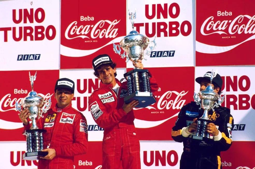 Alain Prost no topo do pódio do GP de 1985, em Jacarepaguá, com Michele Alboreto (à esq.) e Elio de Angelis